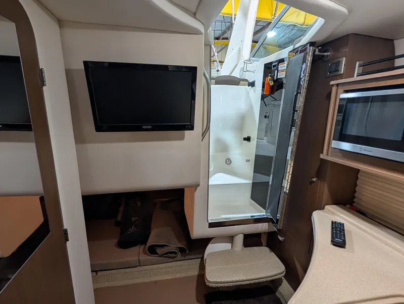 Slide: The Image of Interior of 2015 Sea Ray 280 Sundancer with TV, microwave, and compact seating area. - 16