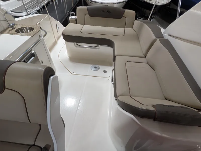 Slide: The Image of 2015 Sea Ray 280 Sundancer interior with beige seating and kitchenette. - 19