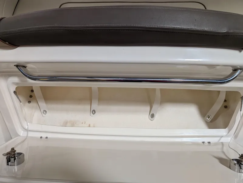 Slide: The Image of 2015 Sea Ray 280 Sundancer storage compartment with cushioned seat and metal handle. - 30