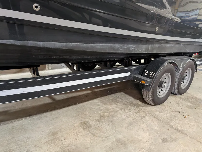 Slide: The Image of 2015 Sea Ray 280 Sundancer on trailer, black hull, dual-axle wheels. - 40