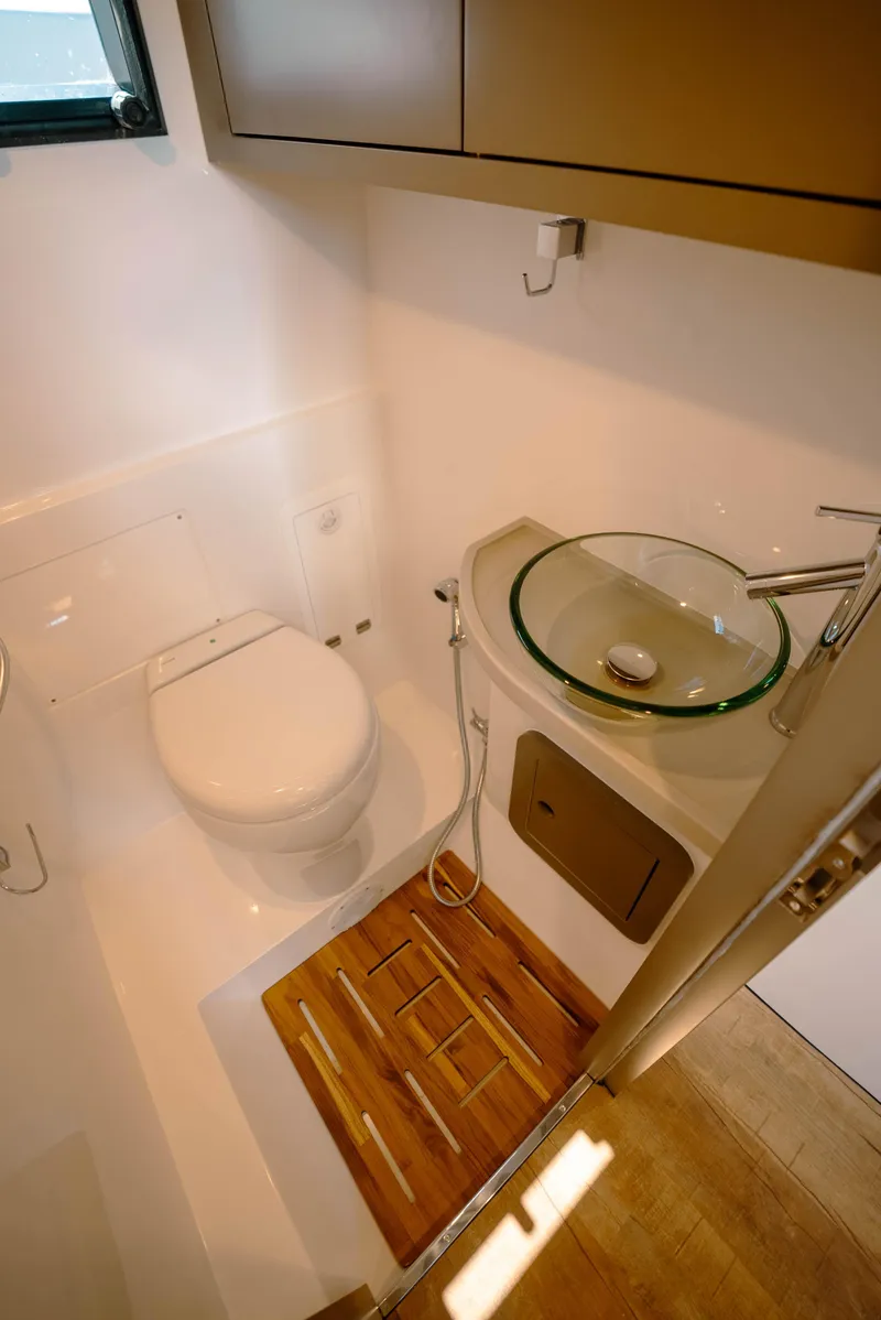 Slide: The Image of Modern bathroom in 2025 Sedna 370 Side Console boat with glass sink and wooden floor mat. - 16