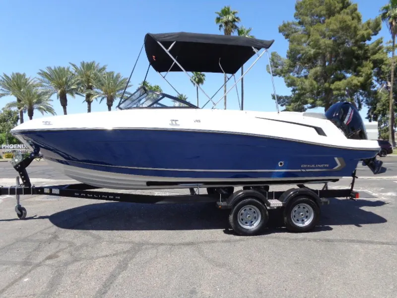 Slide: The Image of 2023 Bayliner VR5 Bowrider OB on trailer, blue and white, parked outdoors. - 9