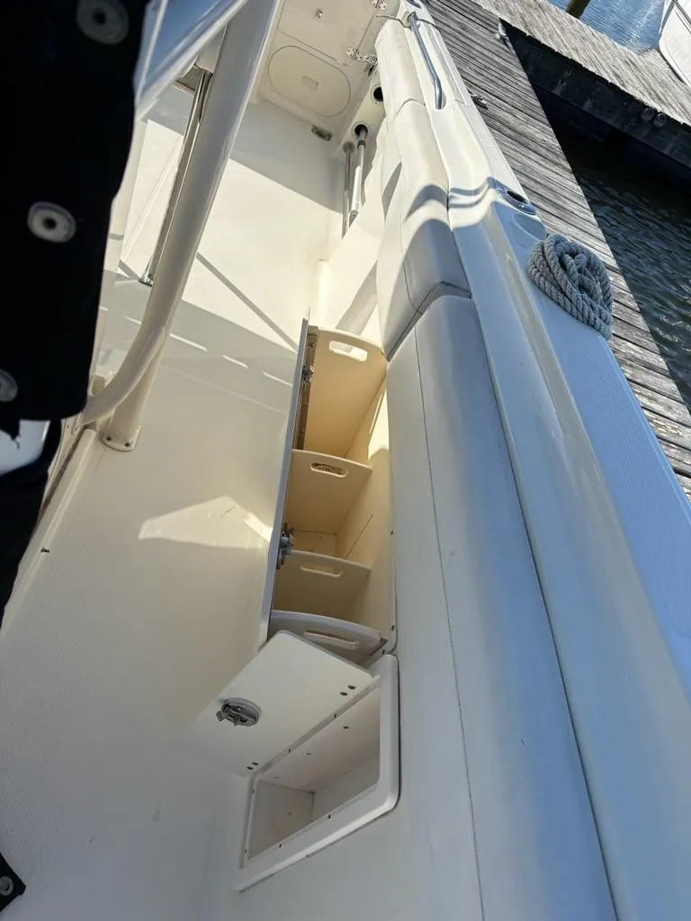 Slide: The Image of 2012 Hydra-Sports 2500 CC boat interior with storage compartments and dock view. - 12