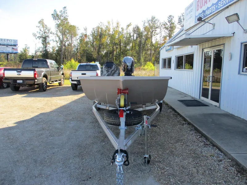 Slide: The Image of 2025 Avid 18 Rogue SC boat on trailer outside dealership, surrounded by trucks and trees. - 2