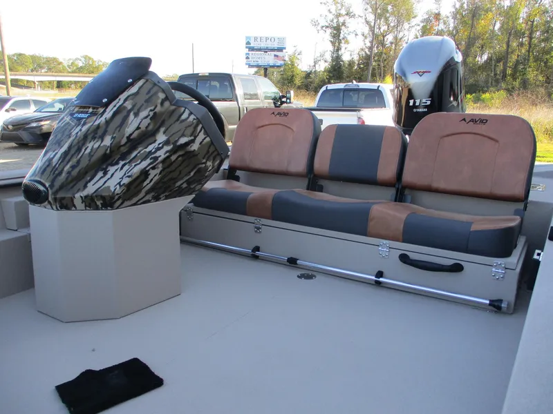 Slide: The Image of 2025 Avid 18 Rogue SC boat interior with camo console and cushioned seating. - 5