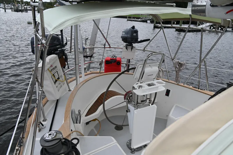 Slide: The Image of 1984 Southern Cross 39 sailboat cockpit with steering wheel and equipment, docked by the water. - 16