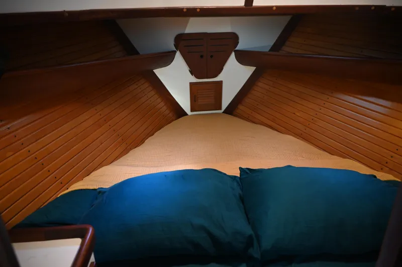 Slide: The Image of Cozy cabin interior of 1984 Southern Cross 39 sailboat with wooden paneling and blue pillows. - 34