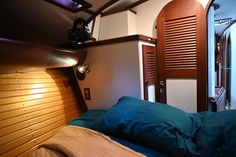 Slide: The Image of Cozy cabin interior of 1984 Southern Cross 39 sailboat with wooden accents and blue bedding. - 35