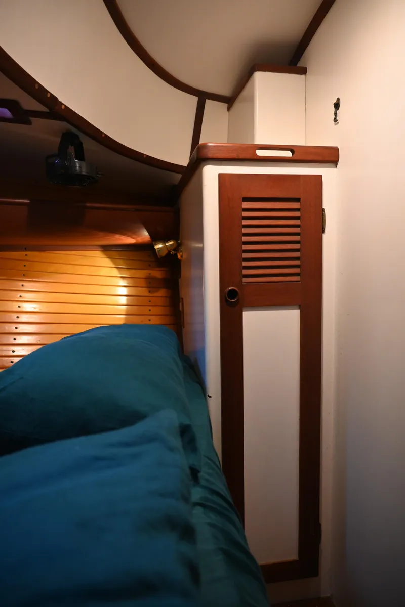 Slide: The Image of 1984 Southern Cross 39 yacht interior with wooden cabinet and cozy bedding. - 36