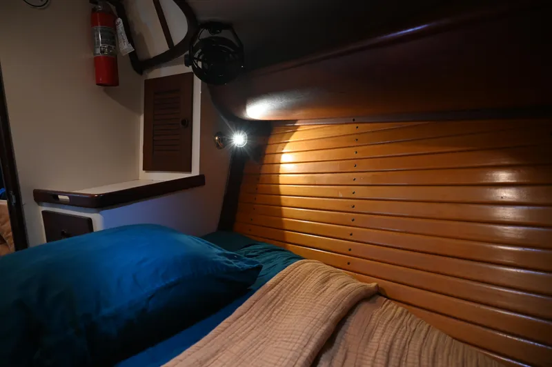 Slide: The Image of Cozy cabin interior of 1984 Southern Cross 39 sailboat with wooden paneling and bedding. - 38