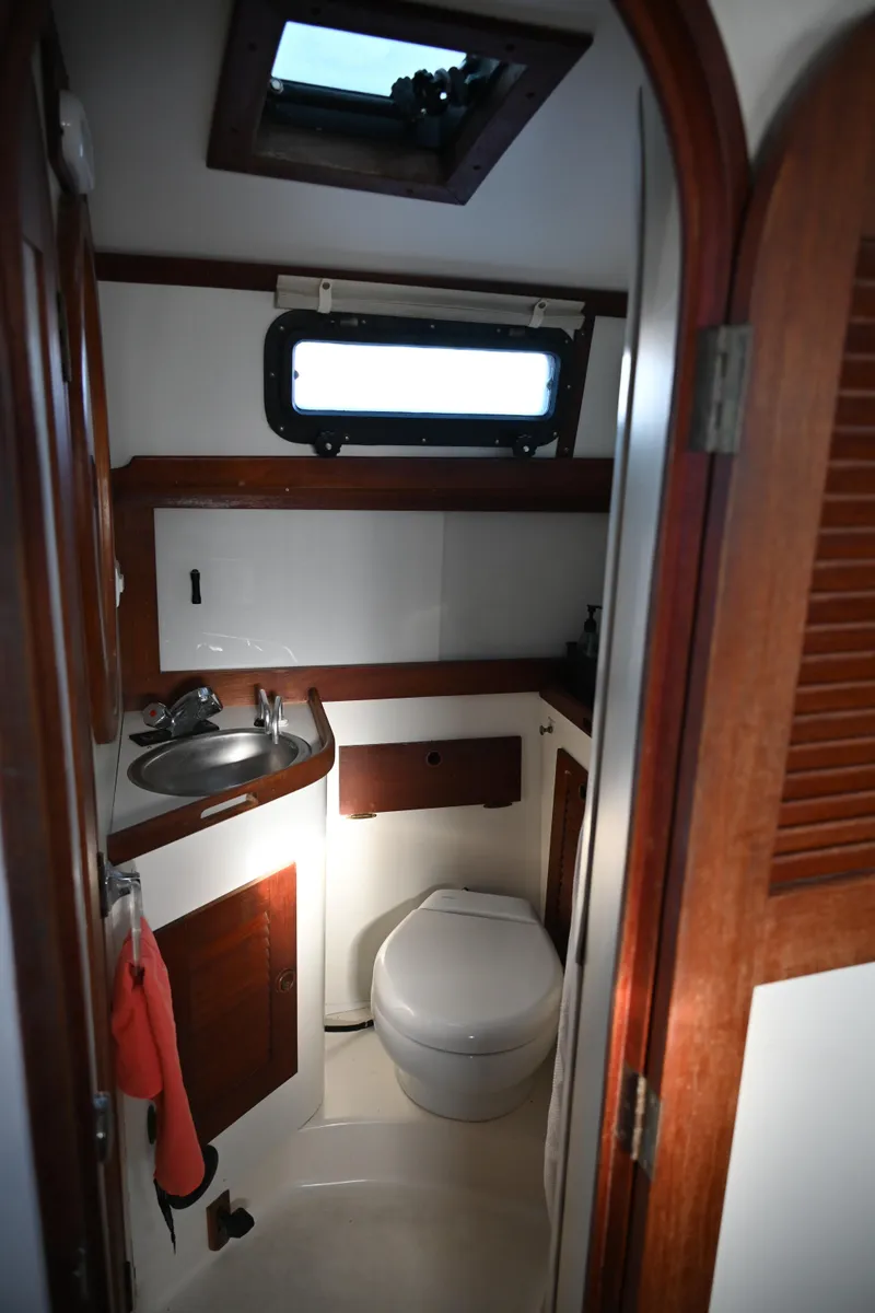 Slide: The Image of 1984 Southern Cross 39 yacht bathroom with sink, toilet, and porthole window. - 46
