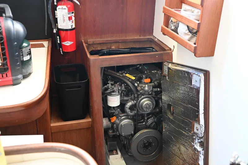 Slide: The Image of Engine compartment of a 1984 Southern Cross 39 sailboat, featuring a visible engine and fire extinguisher. - 48