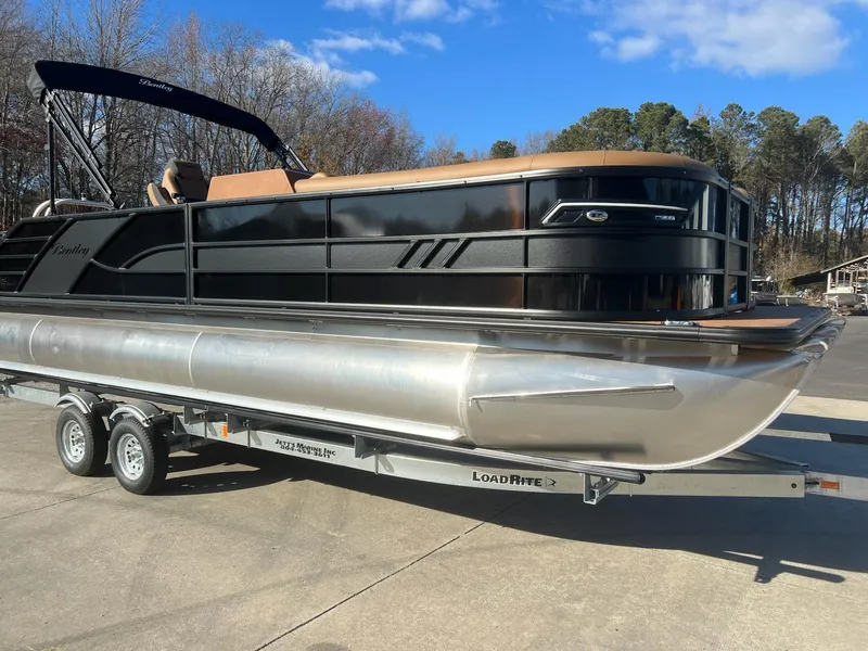 The Image of 2025 Bentley Pontoons 253 Elite Swingback Dual Captain on trailer, sleek design, sunny day. - 1