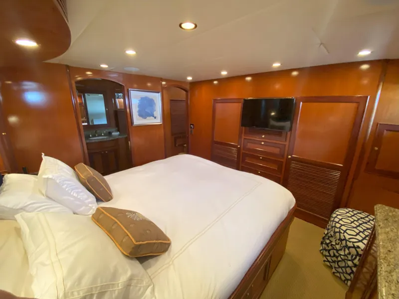 Slide: The Image of Luxurious bedroom in a 2005 Offshore Yachts 72', featuring elegant wood paneling and modern amenities. - 13
