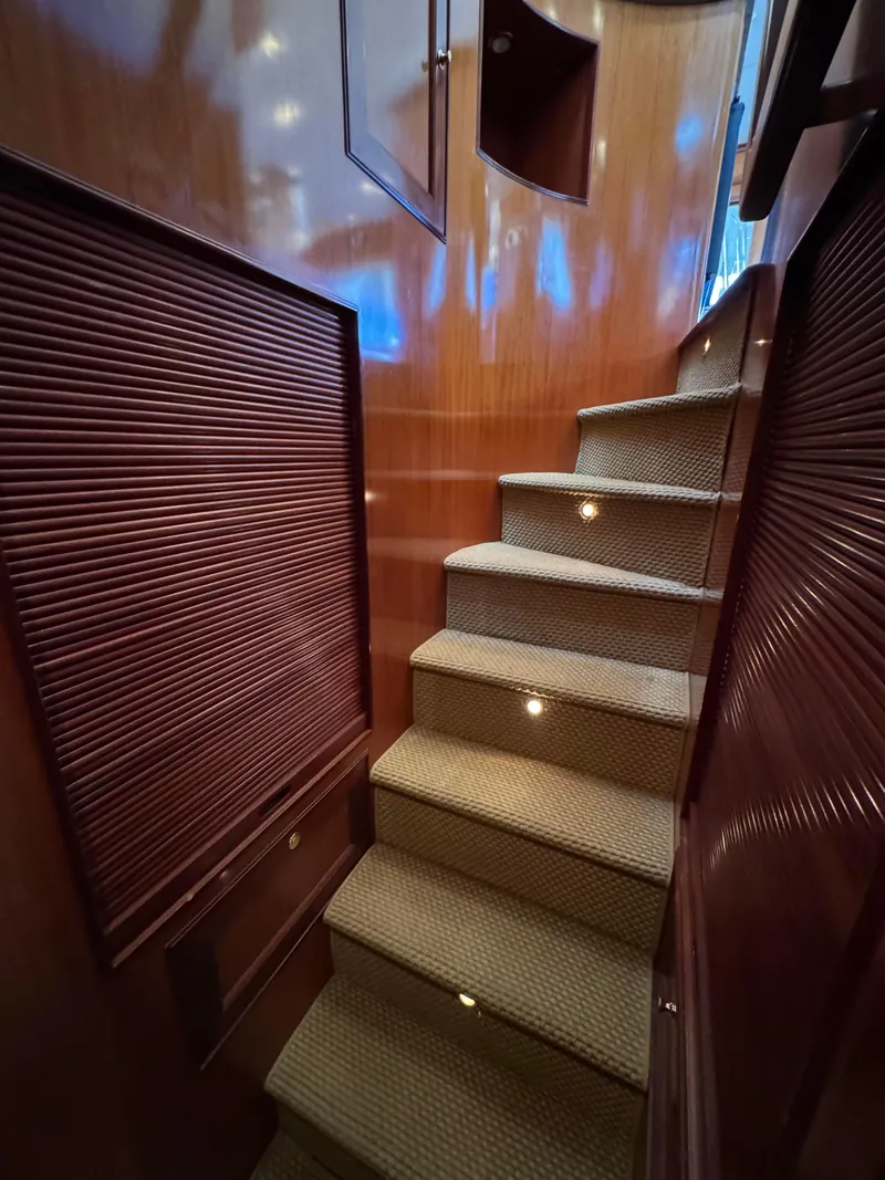 Slide: The Image of Staircase in 2005 Offshore Yachts 72', featuring elegant wood paneling and carpeted steps. - 15