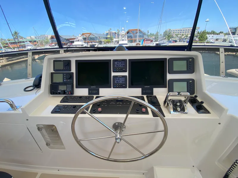 Slide: The Image of Helm of 2005 Offshore Yachts 72', featuring navigation and control systems at marina. - 23