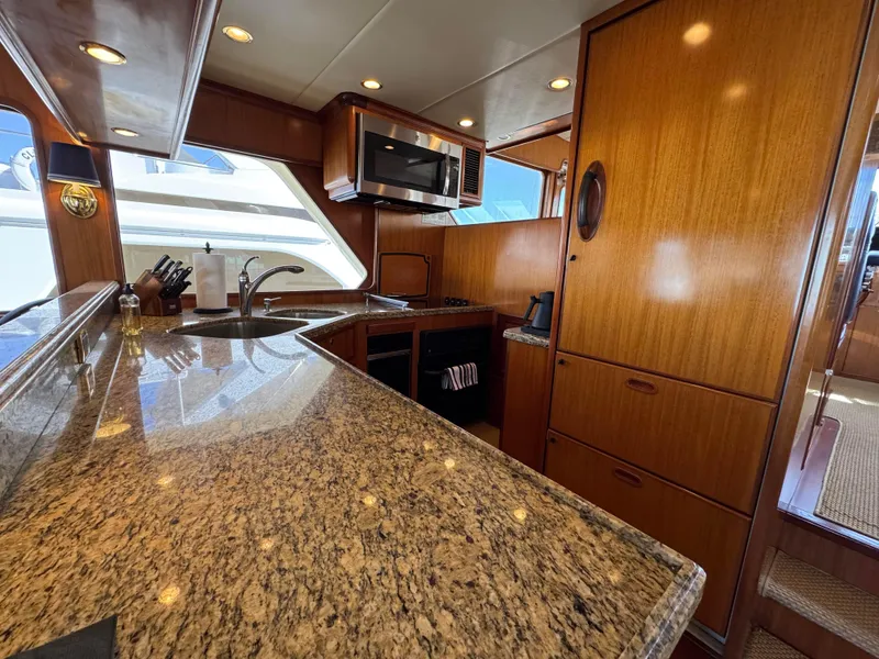 Slide: The Image of Luxurious kitchen interior of 2005 Offshore Yachts 72', featuring granite countertops and wooden cabinetry. - 5