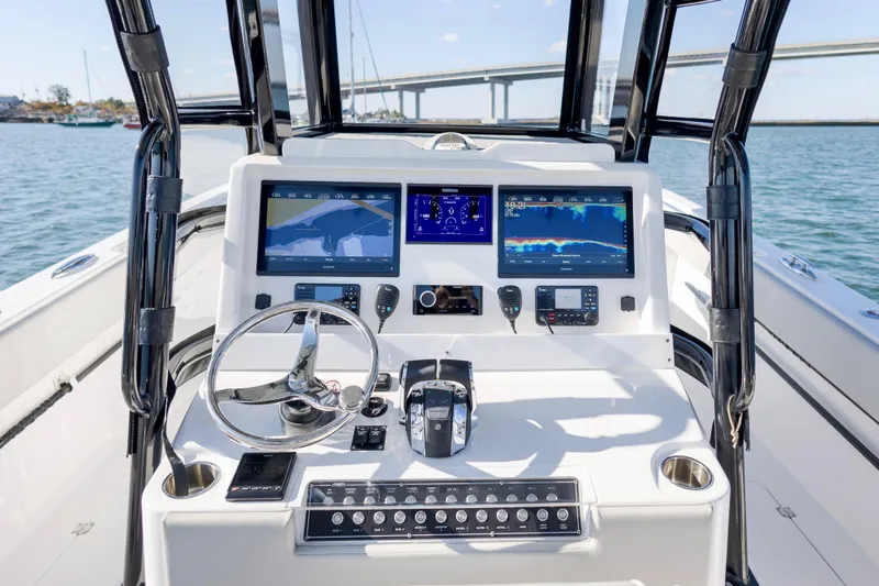 Slide: The Image of 2022 Invincible 33 Catamaran dashboard with dual screens and steering wheel on open water. - 10