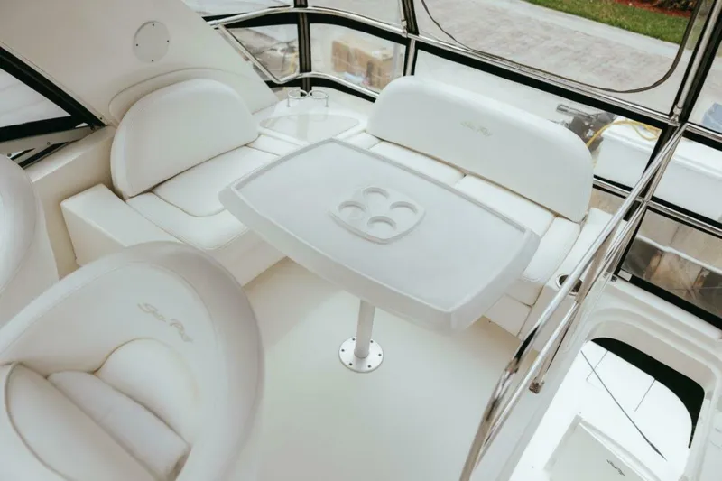 Slide: The Image of Interior of 2010 Sea Ray 390 Sedan Bridge with white seating and table. - 18