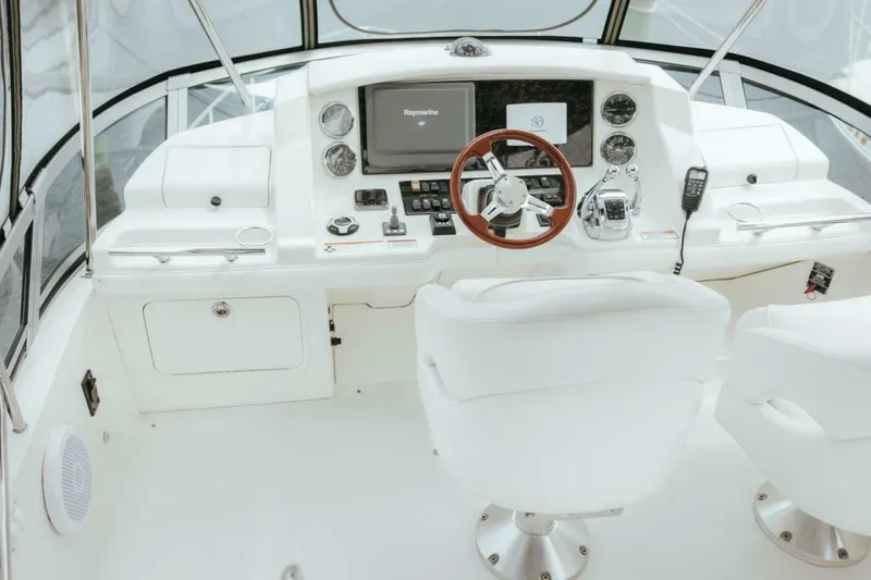 Slide: The Image of 2010 Sea Ray 390 Sedan Bridge helm with modern navigation equipment and white seating. - 19