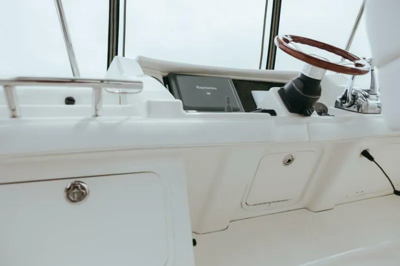 Slide: The Image of 2010 Sea Ray 390 Sedan Bridge helm with wooden steering wheel and navigation equipment. - 20