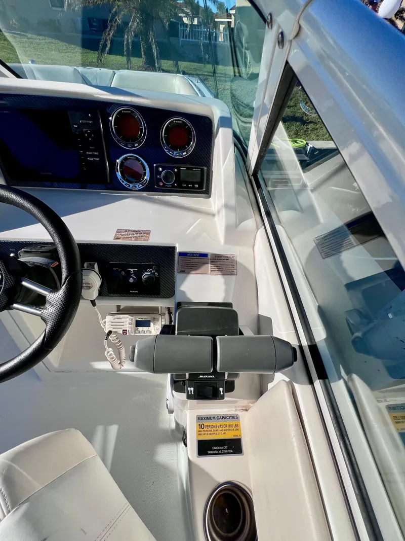 Slide: The Image of 2015 Carolina Cat 23 SD boat dashboard with steering wheel and controls. - 11