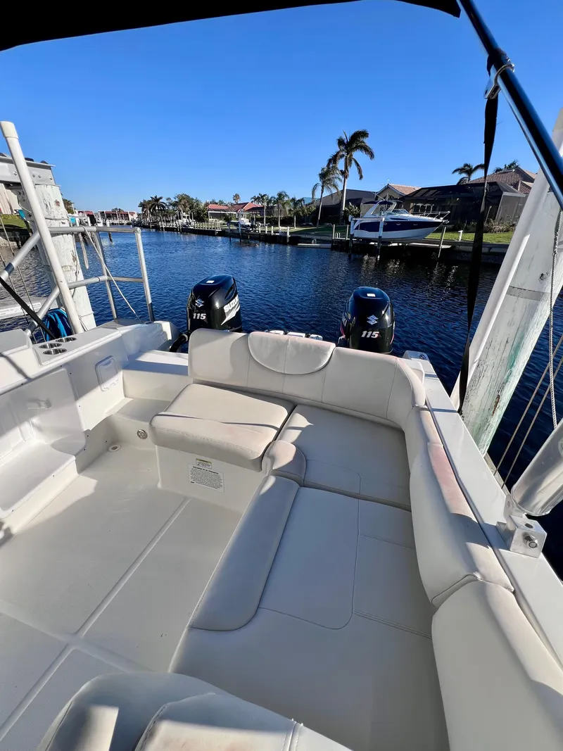 Slide: The Image of 2015 Carolina Cat 23 SD boat with dual engines docked by waterfront homes. - 14