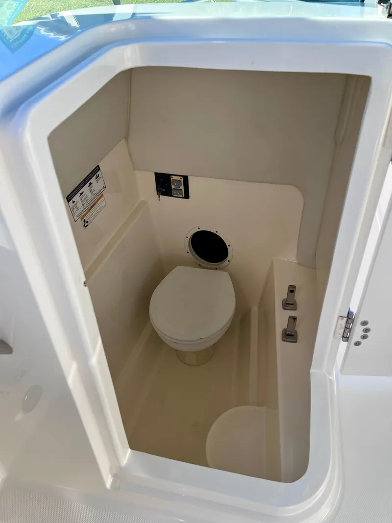 Slide: The Image of 2015 Carolina Cat 23 SD boat interior with compact marine toilet. - 17