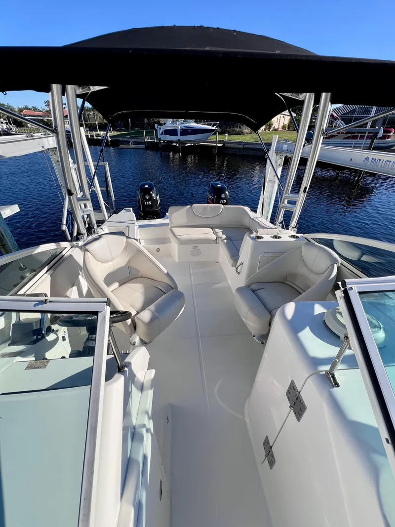 Slide: The Image of 2015 Carolina Cat 23 SD boat interior with seating and canopy on a sunny day. - 23