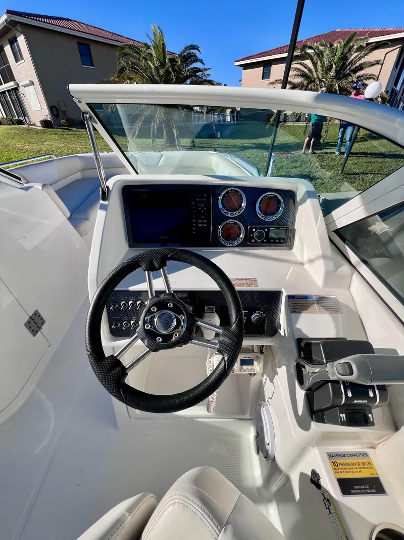 Slide: The Image of 2015 Carolina Cat 23 SD boat dashboard with steering wheel and controls. - 7