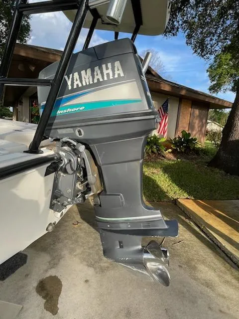 Slide: The Image of 1998 Hewes Bayfisher boat with Yamaha outboard motor, parked in driveway. - 11