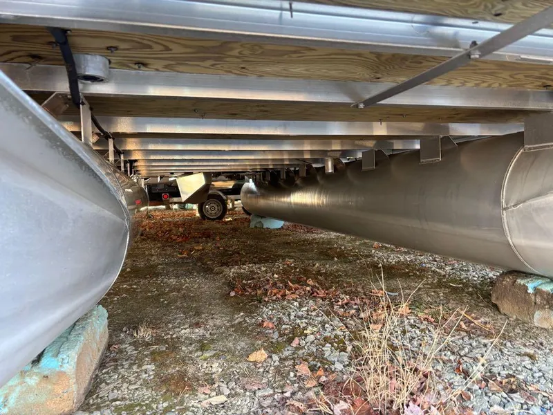 Slide: The Image of Underneath view of 2015 Apex Marine Qwest Adventure 820 pontoon boat on dry land. - 4