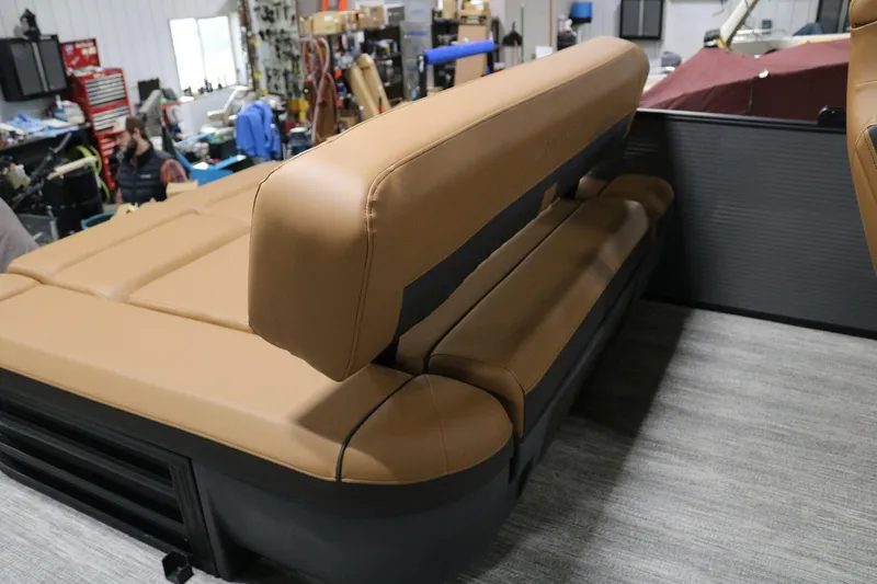 Slide: The Image of 2025 Bennington 22 M Swingback boat interior with tan seating in a workshop. - 20