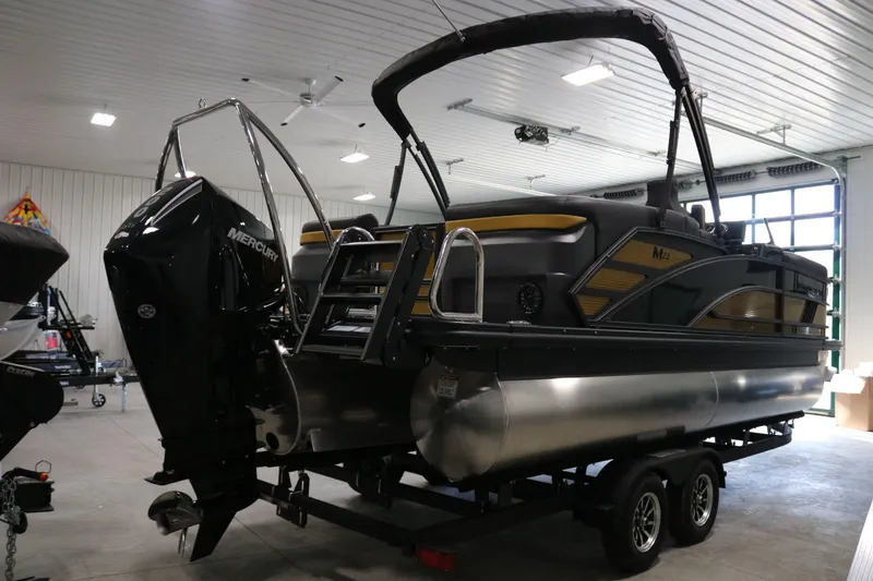 Slide: The Image of 2025 Bennington 22 M FASTBACK pontoon boat in showroom, featuring Mercury outboard motor. - 5
