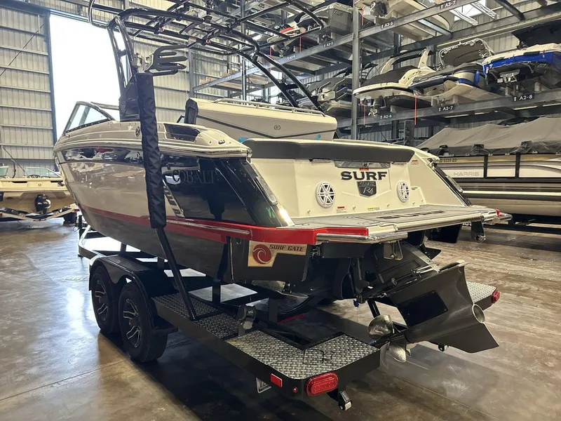Slide: The Image of 2024 Cobalt R4 Surf boat in storage, showcasing rear design and trailer. - 4