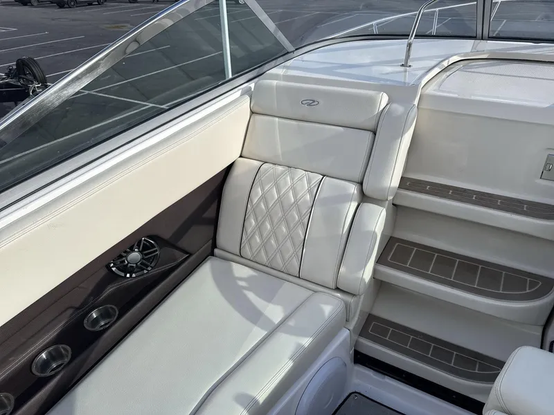 Slide: The Image of 2023 Regal 28EX boat interior with white leather seating and cup holders. - 15