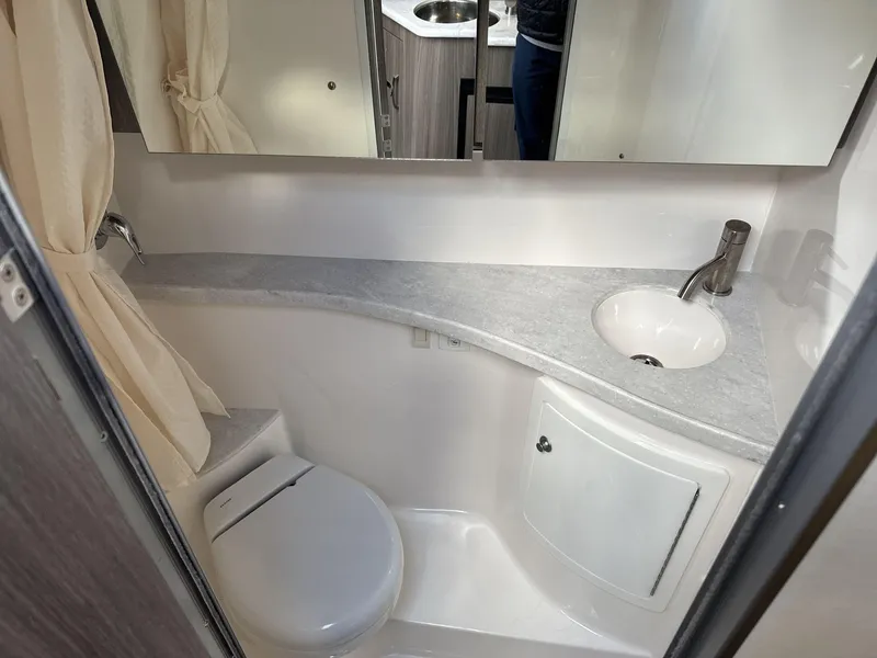 Slide: The Image of 2023 Regal 28EX bathroom with modern sink, toilet, and mirror. - 19