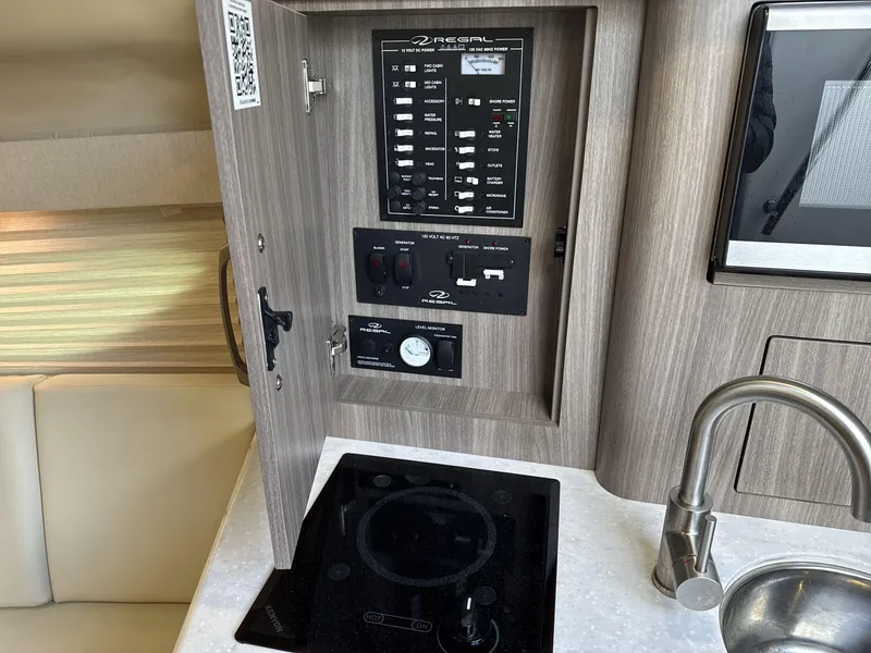 Slide: The Image of 2023 Regal 28EX yacht interior with control panel, stove, and sink. - 20