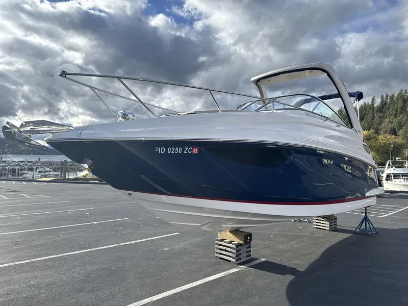 Slide: The Image of 2023 Regal 28EX boat on blocks in parking lot under cloudy sky. - 3