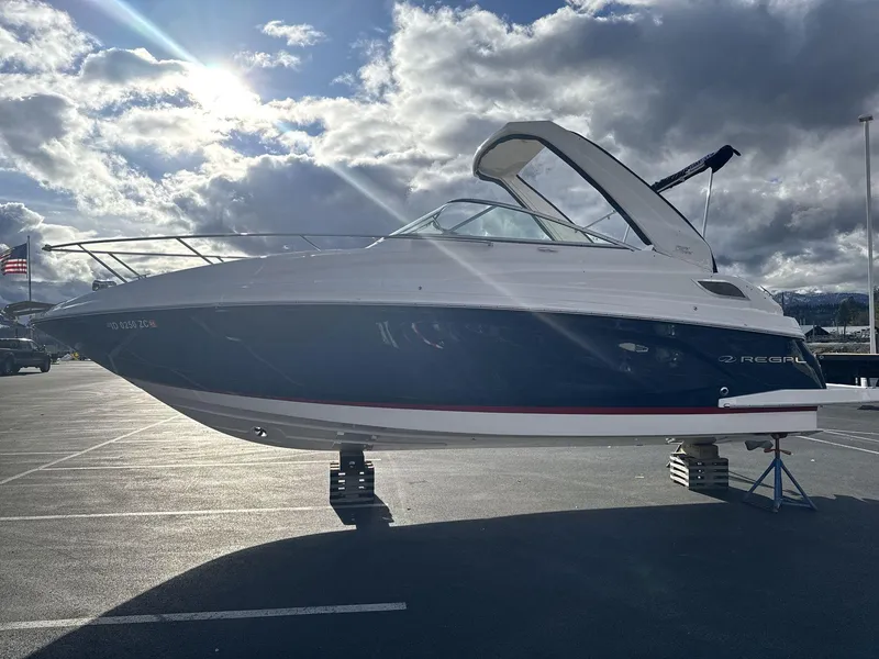 Slide: The Image of 2023 Regal 28EX boat on stands under a cloudy sky. - 4