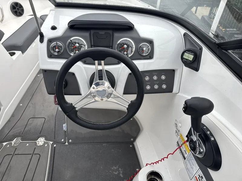 Slide: The Image of 2022 Tahoe 210 S boat dashboard with steering wheel and control panel. - 11