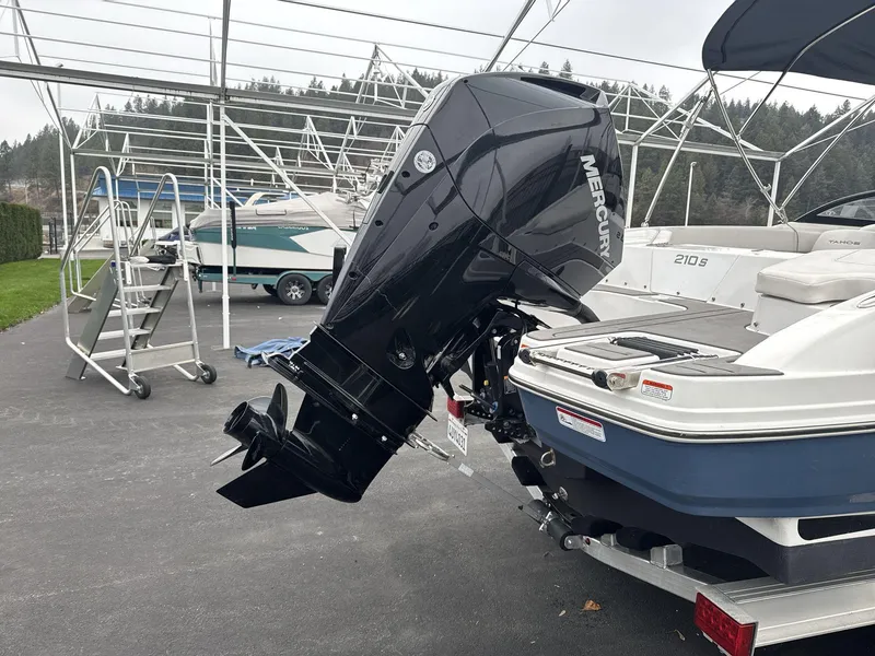 Slide: The Image of 2022 Tahoe 210 S boat with Mercury outboard motor in a marina setting. - 17