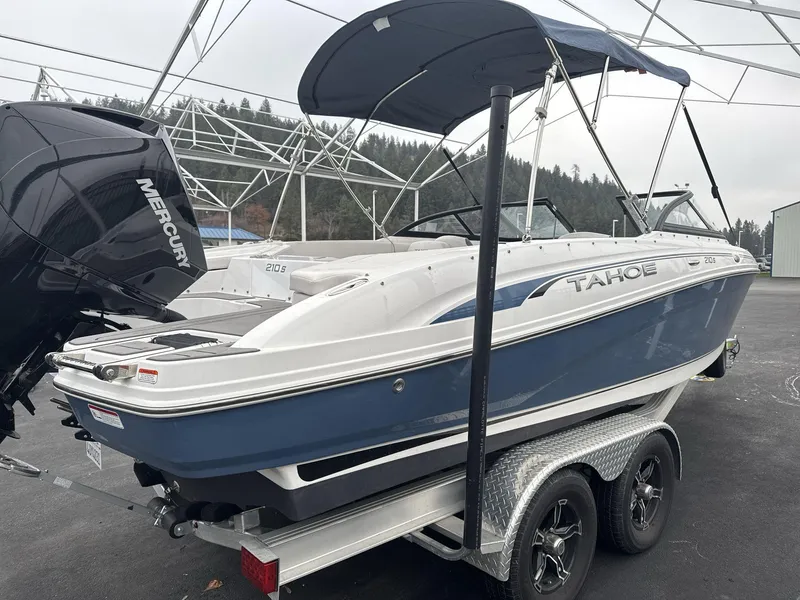 Slide: The Image of 2022 Tahoe 210 S boat on trailer with Mercury engine, parked outdoors. - 4