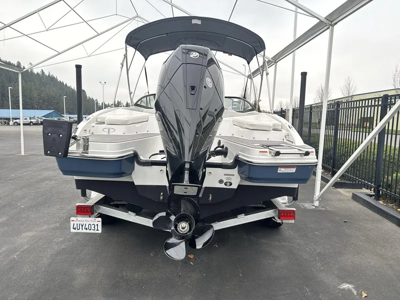 Slide: The Image of 2022 Tahoe 210 S boat on trailer, rear view, under canopy. - 5