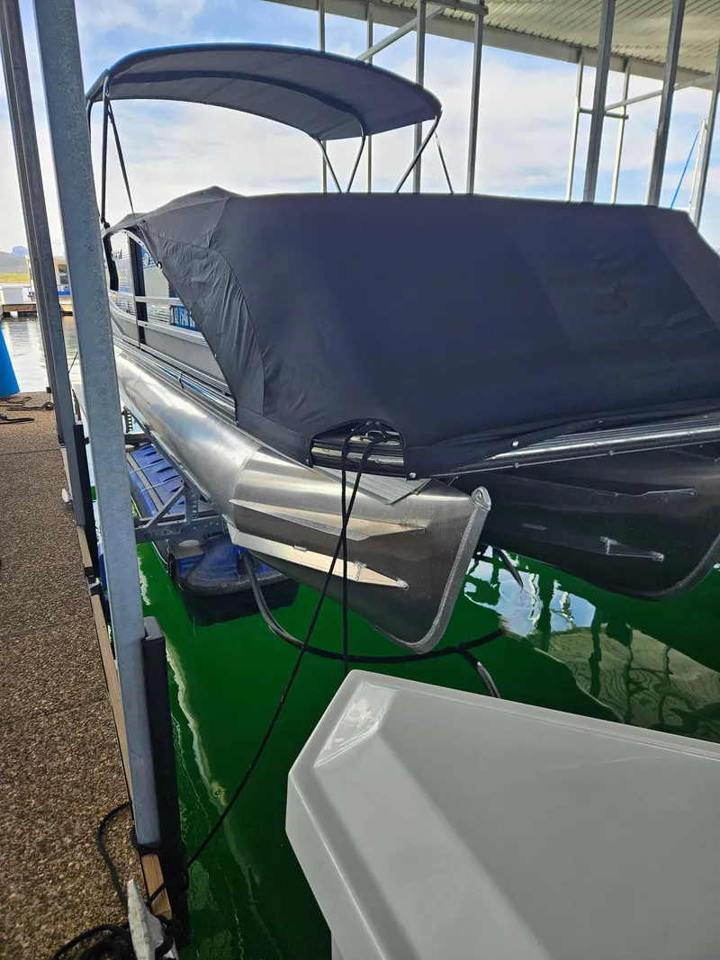 Slide: The Image of 2018 Crest Savanagh pontoon boat docked with cover, under a canopy. - 3