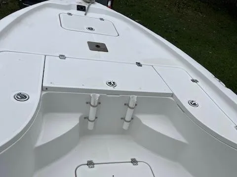 Slide: The Image of 2004 Triton 240 LTS boat deck with storage compartments and rod holders. - 8