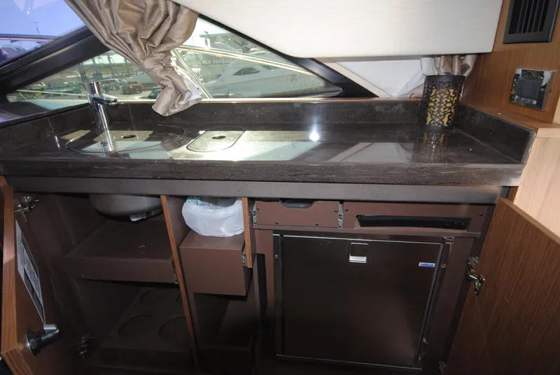 Slide: The Image of 2017 Sea Ray Sundancer 510 yacht kitchenette with sink, countertop, and mini fridge. - 13