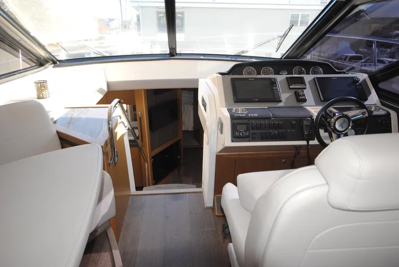 Slide: The Image of 2017 Sea Ray Sundancer 510 yacht interior with helm, seating, and navigation equipment. - 16