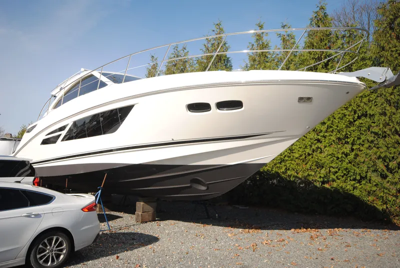 Slide: The Image of 2017 Sea Ray Sundancer 510 yacht on dry land beside a car. - 2