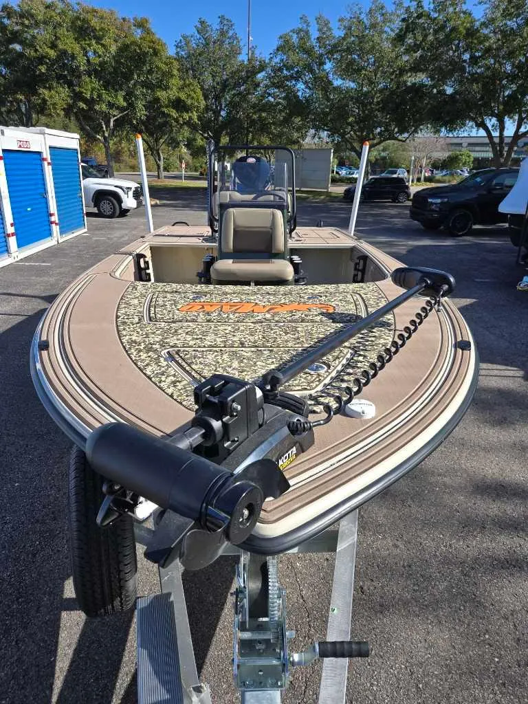 Slide: The Image of 2025 Mako 18 Pro Skiff Backwater Edition boat on trailer, parked outdoors. - 2